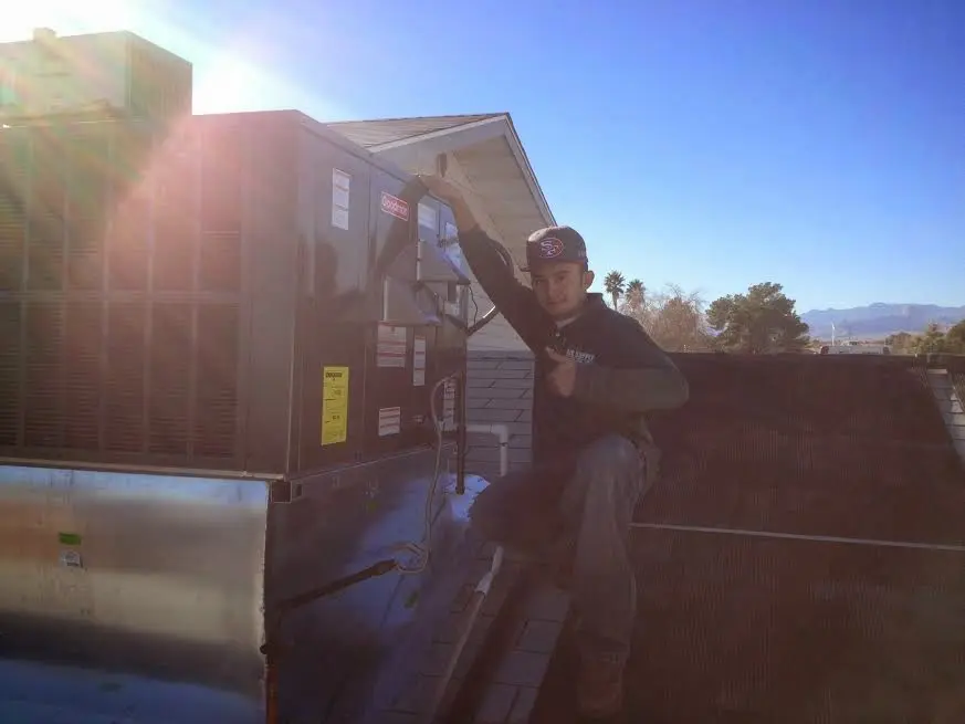 HVAC technician performing Air Duct Cleaning on a rooftop unit in Stone Ridge